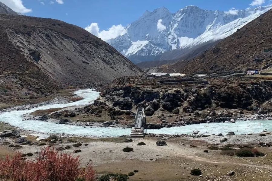 Glacial river crossing with suspension bridge and mountain views on EBC trek
